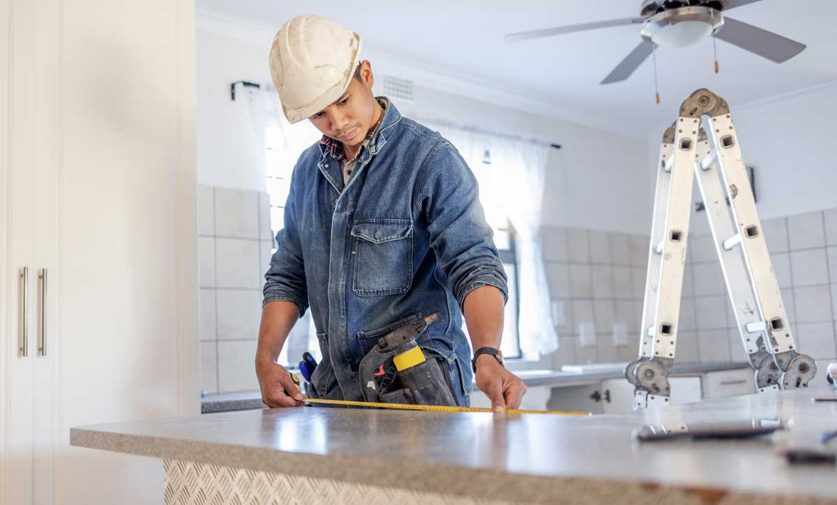 Construction worker remodeling kitchen