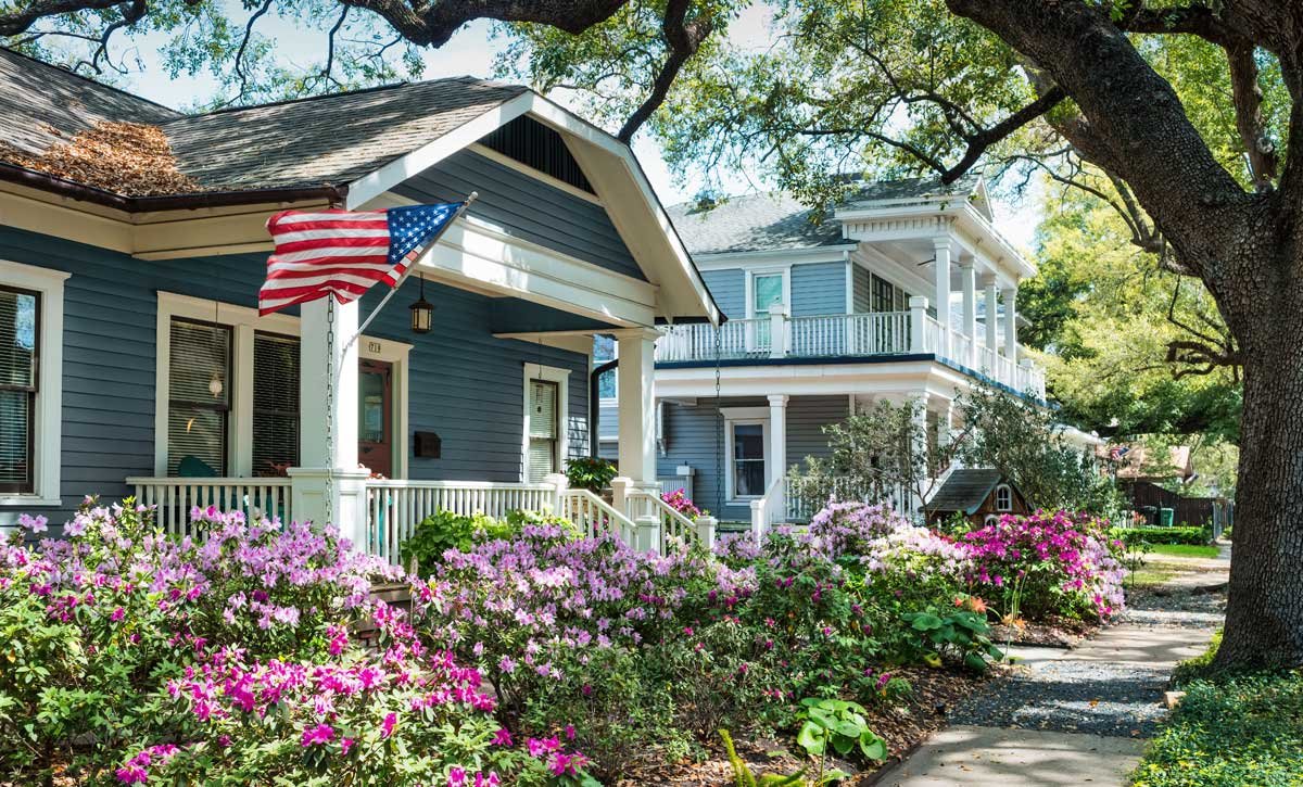 Blue neighborhood home with American flag