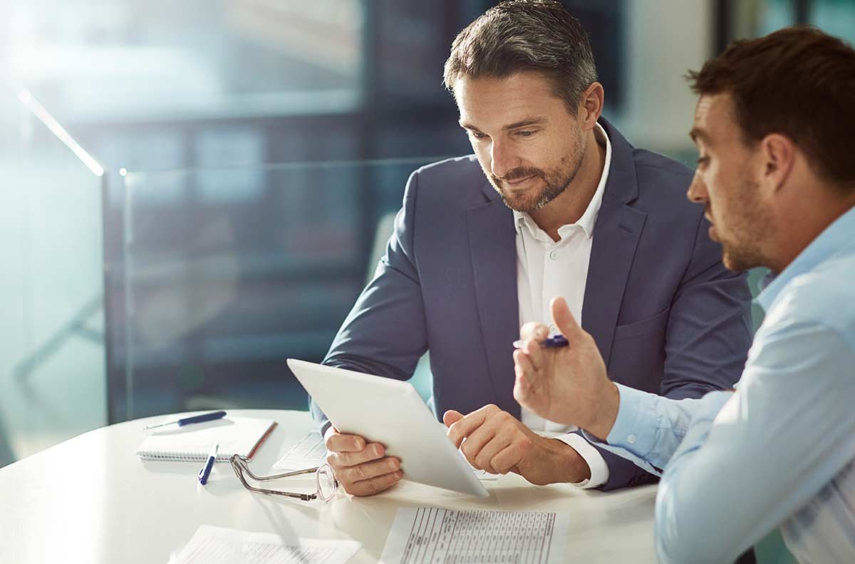 Two business men reviewing paper work at a table